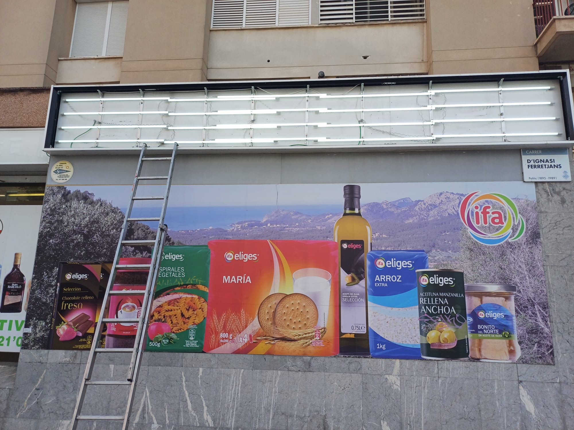 Iluminación de cartel grande supermercado Ferreret son oliva 